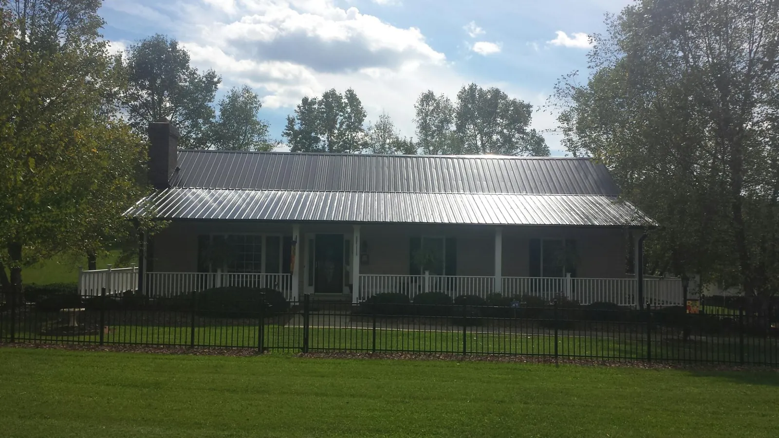 Gray metal roof on a brick ranch with a full width front porch — Gutter Guard Installation work by our crew in Moscow